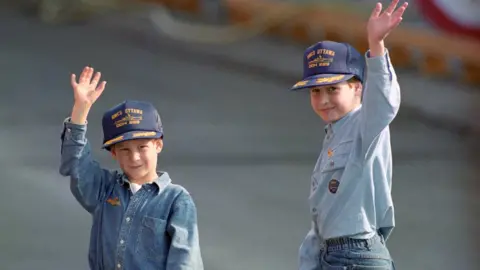  Martin Keene/PA Wire Young brothers in caps