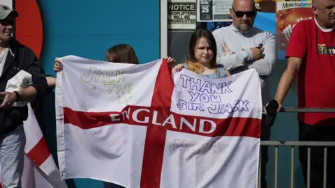Getty Images Two youngsters hold up an England flag with messages celebrating Jack Charlton