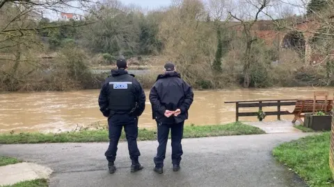 BBC Two police officers stand next to a river