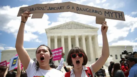 Getty Images Protesters gather outside the US Supreme Court following a court issued immigration ruling 26 June