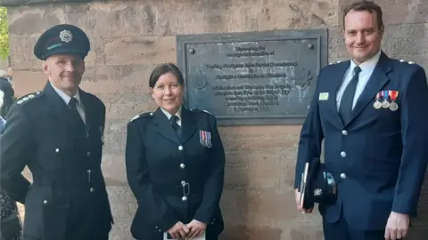 Hereford & Worcester Fire and Rescue Service Firefighters standing next to a plaque