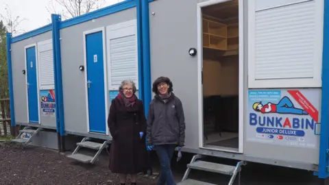 St Albans Council Volunteers Mary and Jackie beside the emergency accommodation