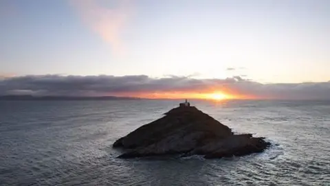 Mark de'Boer Lloyd Mark de'Boer Lloyd took this picture of the sun rising behind Mumbles lighthouse.