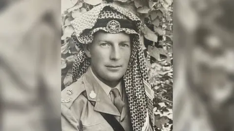 Family Handout A young John Hamilton during service wearing his military uniform and a desert warfare head covering