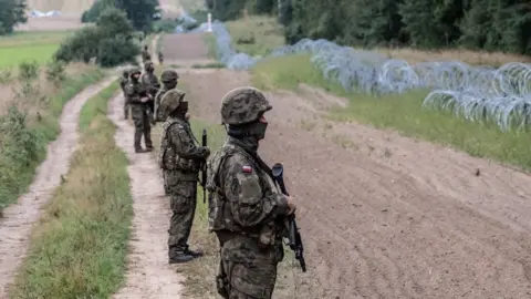 Getty Images Polish army soldiers in front of border between Poland and Belarus. On August 26, 2021