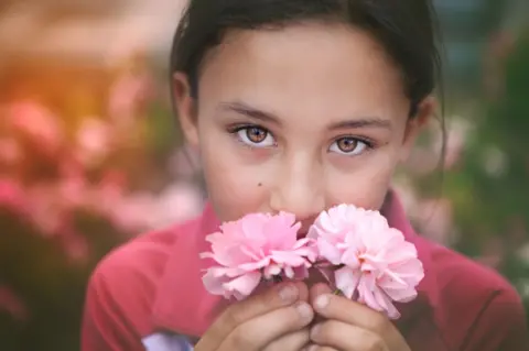 Getty Images Girl smelling roses