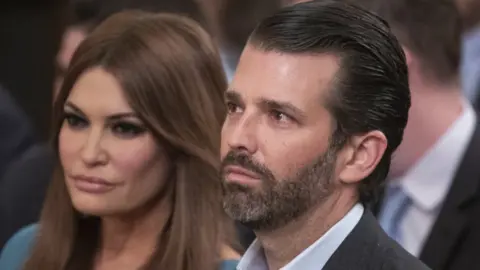 Getty Images Donald Trump Jr and his girlfriend, Kimberly Guilfoyle, sitting next to each other