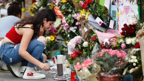 AFP A girl lights a candle outside Notting Hill Methodist Church in west London