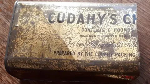 Tarnished tin container bearing the name Cudahy's