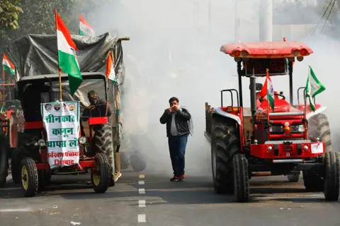 ADNAN ABIDI/REUTERS A farmer covers his face to protect himself from tear gas