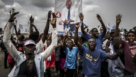 Getty Images Supporters of opposition leader Martin Fayulu march and chant slogans in the streets of the Ndjili district of Kinshasa, 19 December 2018