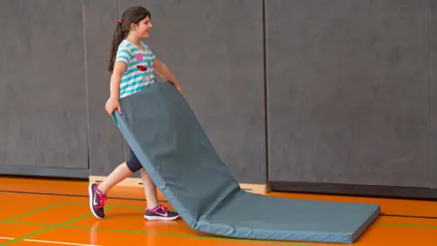 Alamy Girl with a PE mat