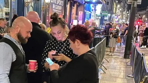 BBC A doorman checking covid passes