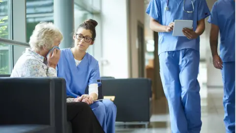 Getty Images Nurse talking to a women about her illness