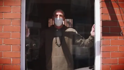 Man wearing face mask by window