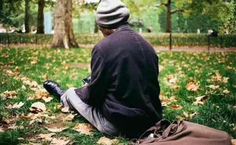 Venetia Menzies Sunny relaxes in St James's Park, with his tote bag behind him