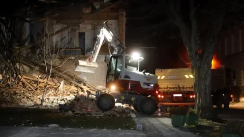 EPA Workers clear a building damaged in an earthquake in Petrinja, Croatia, 29 December 2020