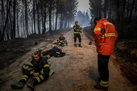 Patricia De Melo Moreira / AFP Firefighters drink water and recover during an operation to stop a wildfire in the Sameiro village near the town of Manteigas, Portugal, on 10 August 2022