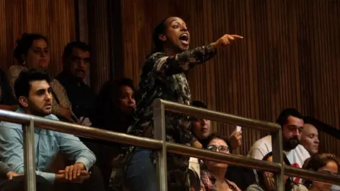 Getty Images A person heckling at the meeting