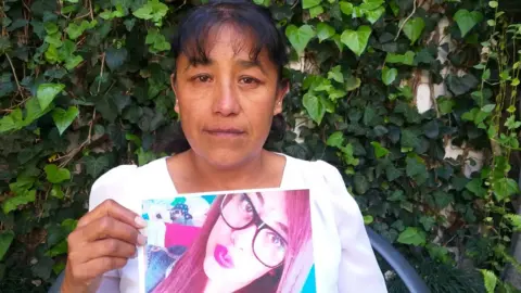Araceli holding up a picture of her murdered daughter Abigail