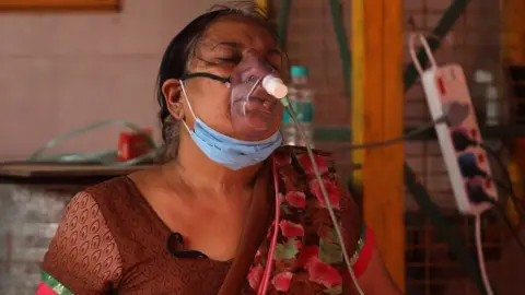 Getty Images A woman in India breaths through an oxygen mask