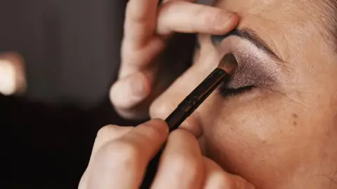 Getty Images Eyeshadow is applied to a woman's left eyelid, side view