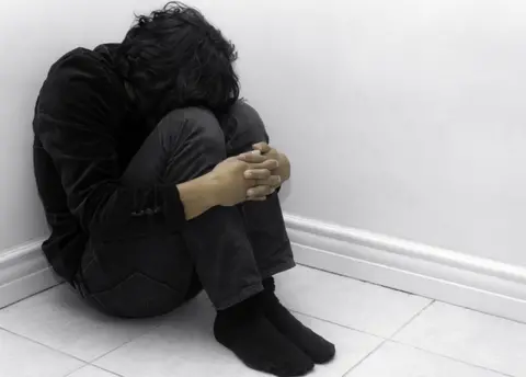 EPA A stock image of a young person curled up into a ball