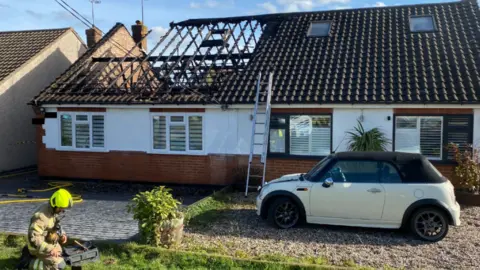 ESSEX FIRE AND RESCUE Bungalow with roof missing and charred timbers on display.