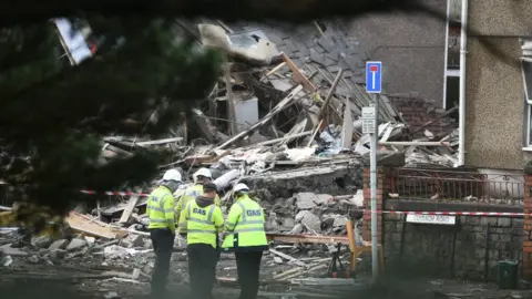 Robert Melen Gas engineers outside damaged property in Swansea