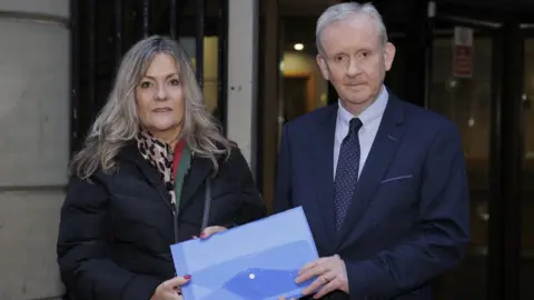 Liam McBurney/PA Media Monica Heaney presents the petition to Department for Infrastructure Permanent Secretary Denis McMahon