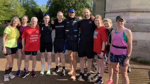 Joshua Patterson standing with a group of runners