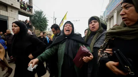 Reuters A relative mourns during the funeral of Palestinian Mufeed Ikhlil, 44, near Hebron in the occupied West Bank (29 November 2022)