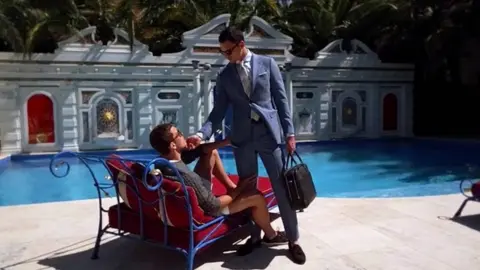 Suitsupply Two male models hold each other next to a swimming pool in an advert