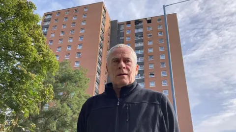 Mark Barrett outside the block of flats