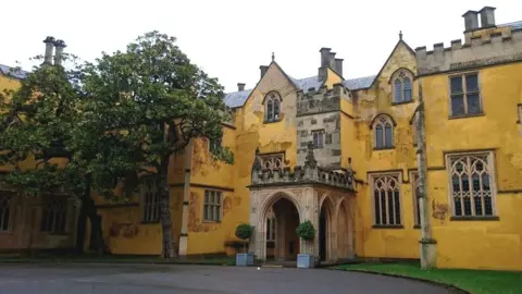 BBC The main entrance to Ashton Court Mansion, with trees either side