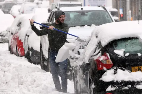 AFP A man clears snow from his car in Auchterarder, Perth and Kinross, on 14 January 2021