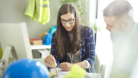 Getty Images A woman in an office with a man
