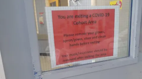 Huw Roberts Sign reading "You are exiting a Covid-19 cohort area"