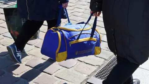 Reuters Two Ukrainian refugees holding a Ukraine bag