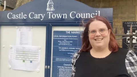 Katie Armstrong by the Castle Cary Town Council notice board