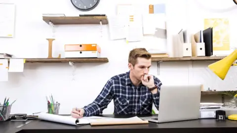 Getty Images A man works through paperwork