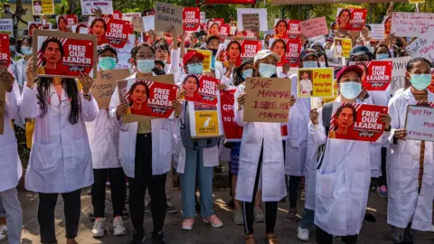 Getty Images Doctors join a protest against the military coup in front of the Chinese Embassy on February 12, 2021 in Yangon, Myanmar.