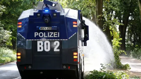 Reuters A police water cannon is used to hose trees in Bochum, Germany, 31 July 2018