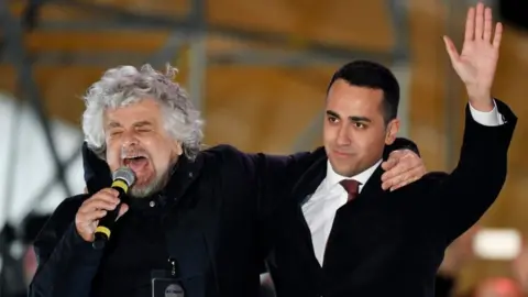 AFP/Getty Images Beppe Grillo speaks next to Luigi Di Maio at a campaign meeting in Piazza del Popolo square in Rome