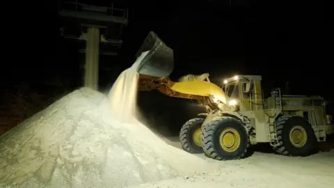 PA a mechanical shovel stockpiling rock salt,