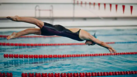 Getty Images Woman diving into a swimming pool - stock photo