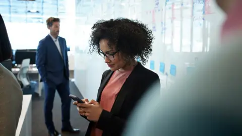 Getty Images Woman on phone in office