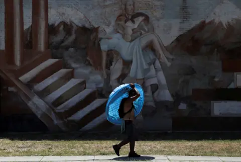 LISA KRANTZ / Getty Images Daniel Bosquez carries a plastic pool to his friend's apartment, as San Antonio is under an excessive heat warning, in San Antonio, Texas, USA. 11 July 2022.
