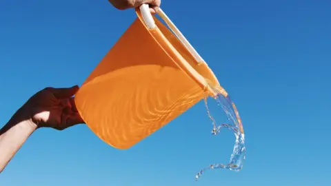 Getty Images A bucket with water in it being tipped