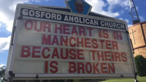 ROD BOWER Gosford Anglican Church billboard reads: "Our heart is in Manchester because theirs is broken"